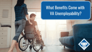 Photo of a woman pushing a man in a wheel chair in a living room. Article title is in blue in the top right corner: What Benefits Come with VA Unemployability?
