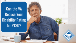 Photo of a man with curly gray hair and a denim button-up sitting at a desk with a coffee cup, documents, and a laptop, and the article title is in the upper left hand corner: Can the VA Reduce Your Disability Rating for PTSD?