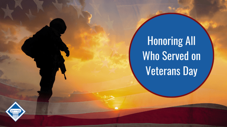 Shadow of a soldier stands on the left side of the photo. The sun sets in the background, clouds are in the sky, and a faint, transparent American flag is in the background. Article title to the right: Honoring All Who Served on Veterans Day.