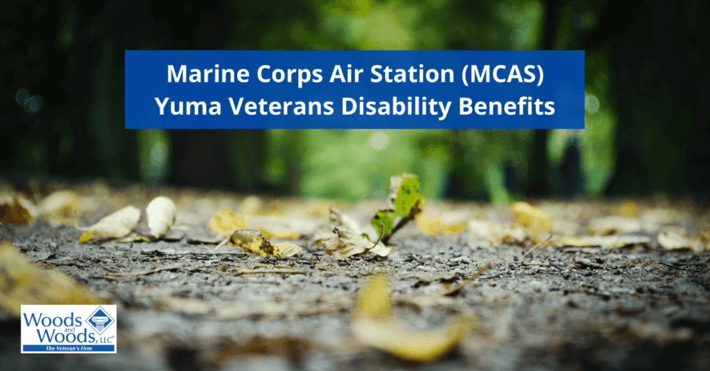Image of the ground that has dirt and is covered in leaves. Marine Corps Air Station (MCAS) Yuma Veterans Disability Benefits is the title in the top center. The Woods and Woods logo is in the bottom left corner.