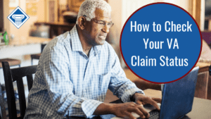 A man in a light blue plaid shirt with glasses and white hair sits at a table, using a laptop. Over the image is a blue circle reading the article title: How to check your VA claim status