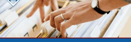 A woman's hands flip through files in a file cabinet. Over the image is a blue banner reading the article title: What happens at the VA evidence intake center?