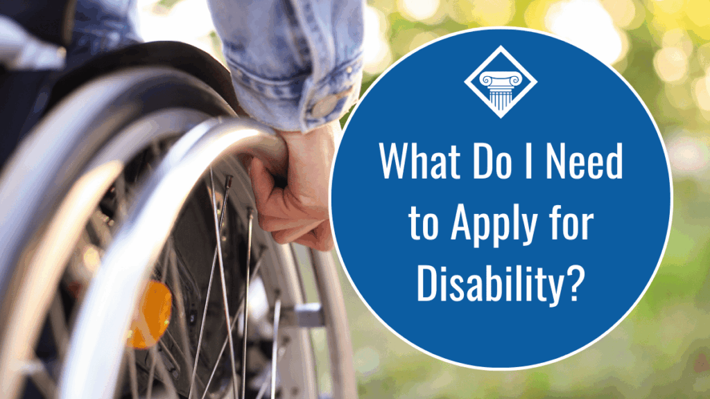 Image of close up of a wheel chair wheel with a person's hand. The title of the article reads, "What Do I Need to Apply for Disability?" and is on the right side of the image, in a blue circle with the Woods & Woods logo.