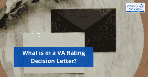 Image of a black envelope and a white piece of paper on a countertop. What is in a VA Rating Decision Letter is the title in the lower left corner. The Woods and Woods logo is in the upper right corner.