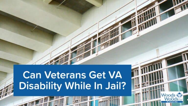 Picture of the inside of an empty jail with 2 floor of cells with their doors open. Our title is in front: Can Veterans Get VA Disability While in Jail?