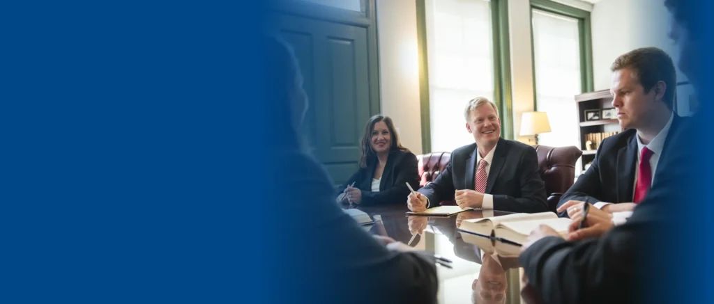 The team of VA disability lawyers at Woods and Woods sitting around a table.