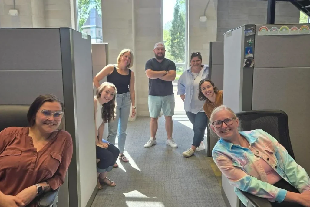 Team members looking out from their cubicles.